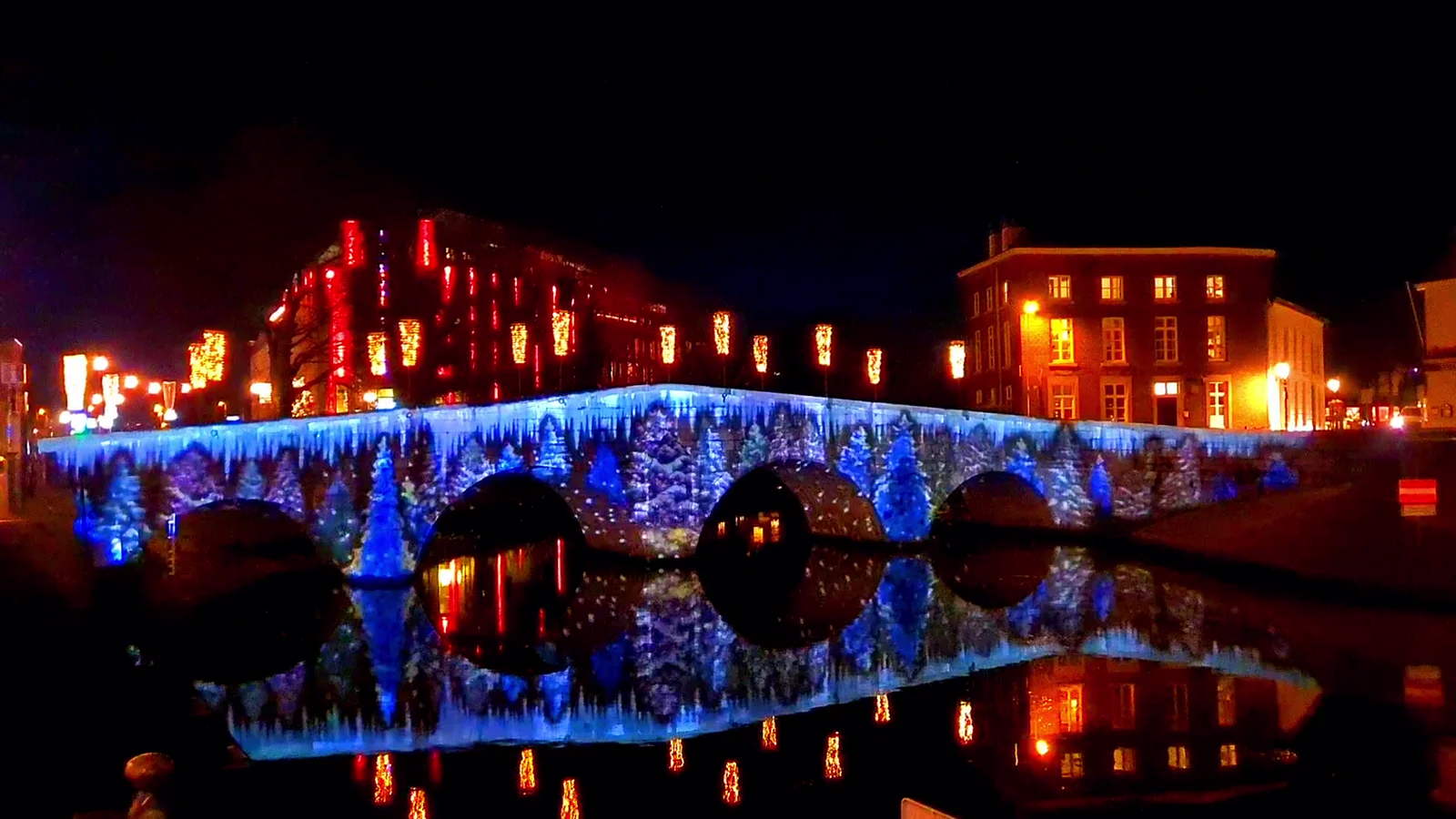 Bridge in Roermond with blue light projection reflected in the water during ROERMONDVOL Licht