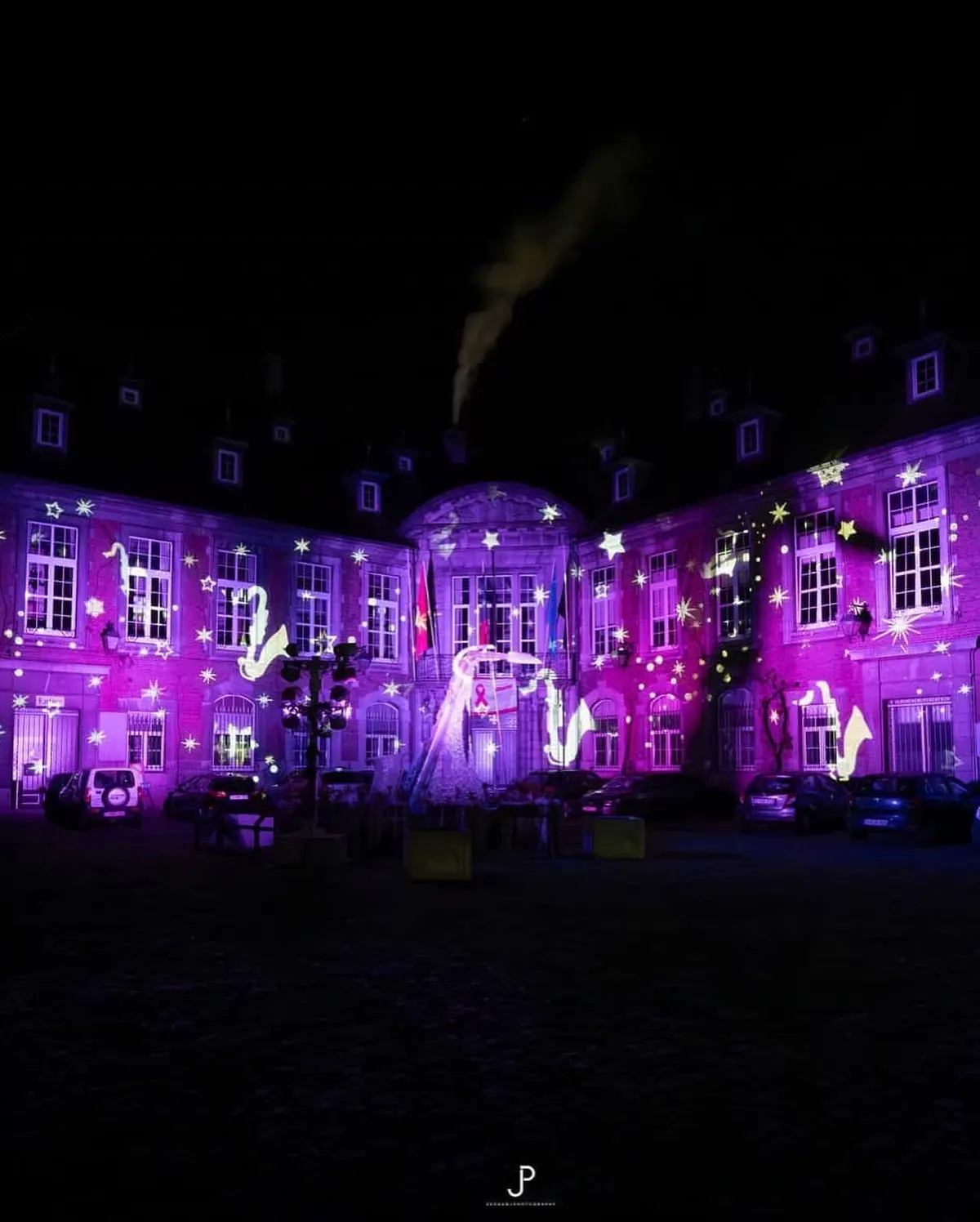 Projection d’étoiles violettes avec des motifs de saxophone sur une façade à Dinant