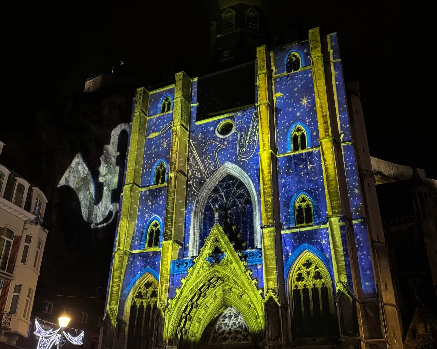 Collegiale kerk van Dinant bij nacht met blauw-gele lichtprojectie op de gevel